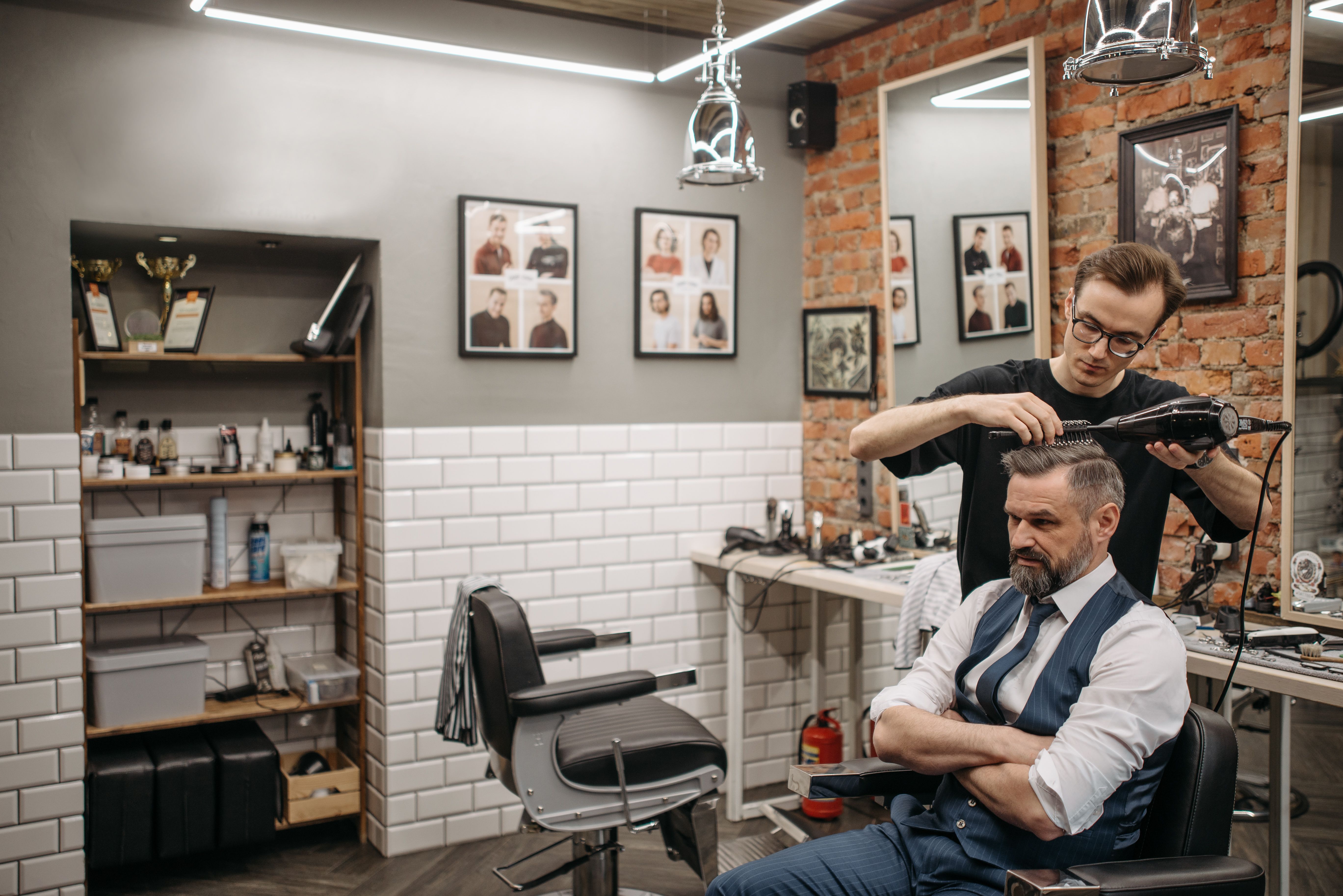 Barber styling a client's hair in a modern barbershop