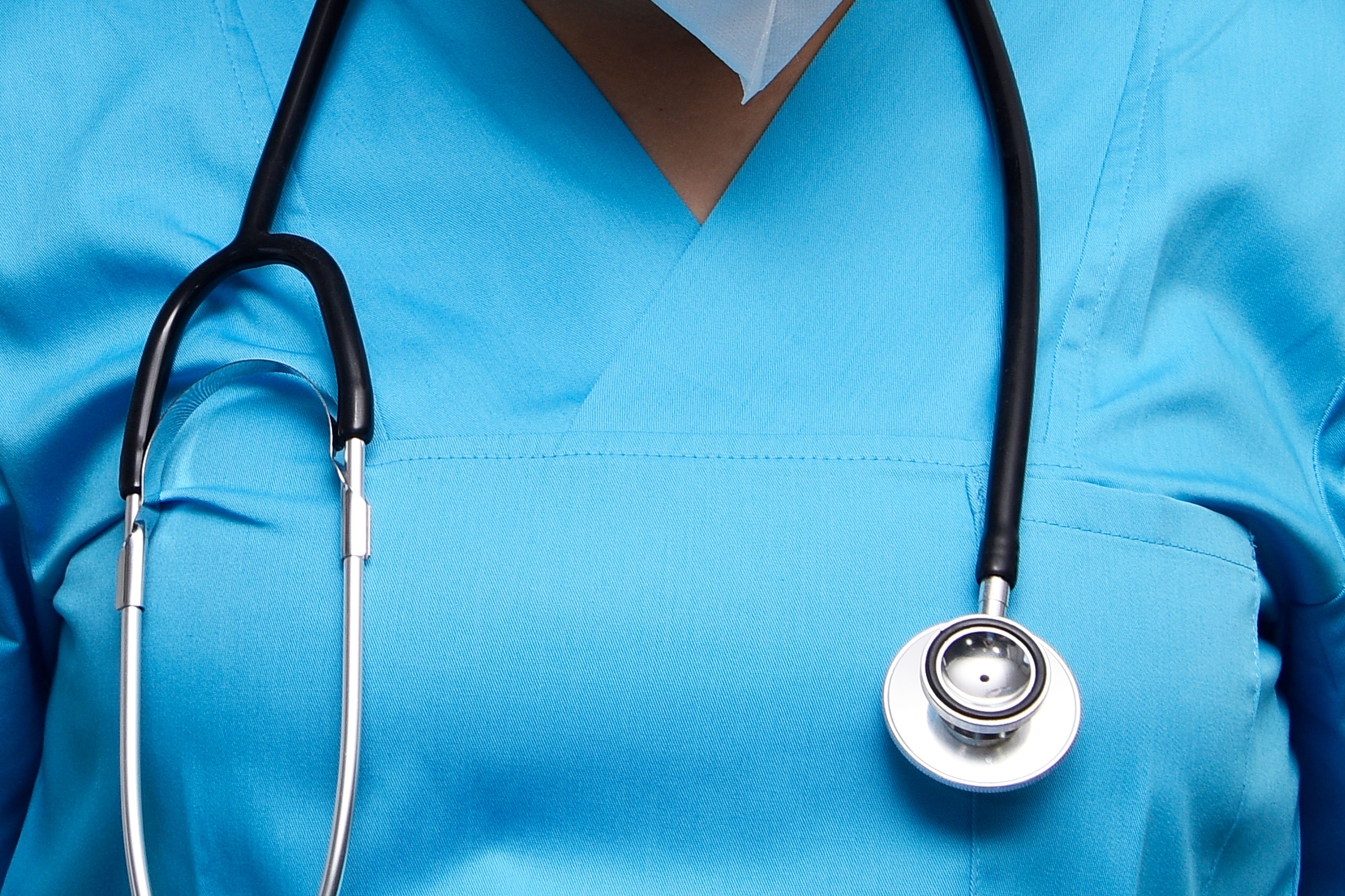 NHS healthcare professional wearing blue scrubs with stethoscope