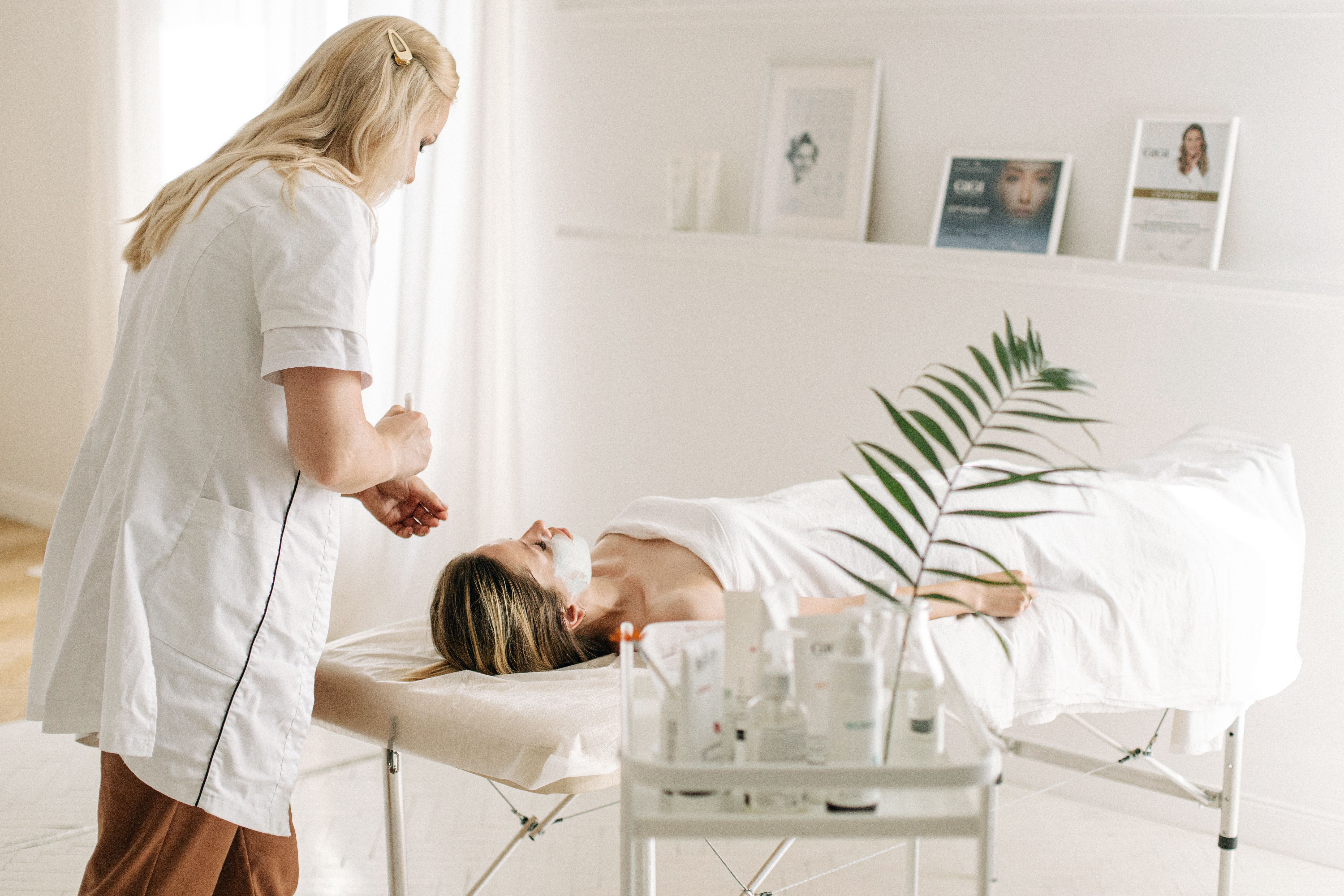 Self-employed beautician performing a facial treatment on a client
