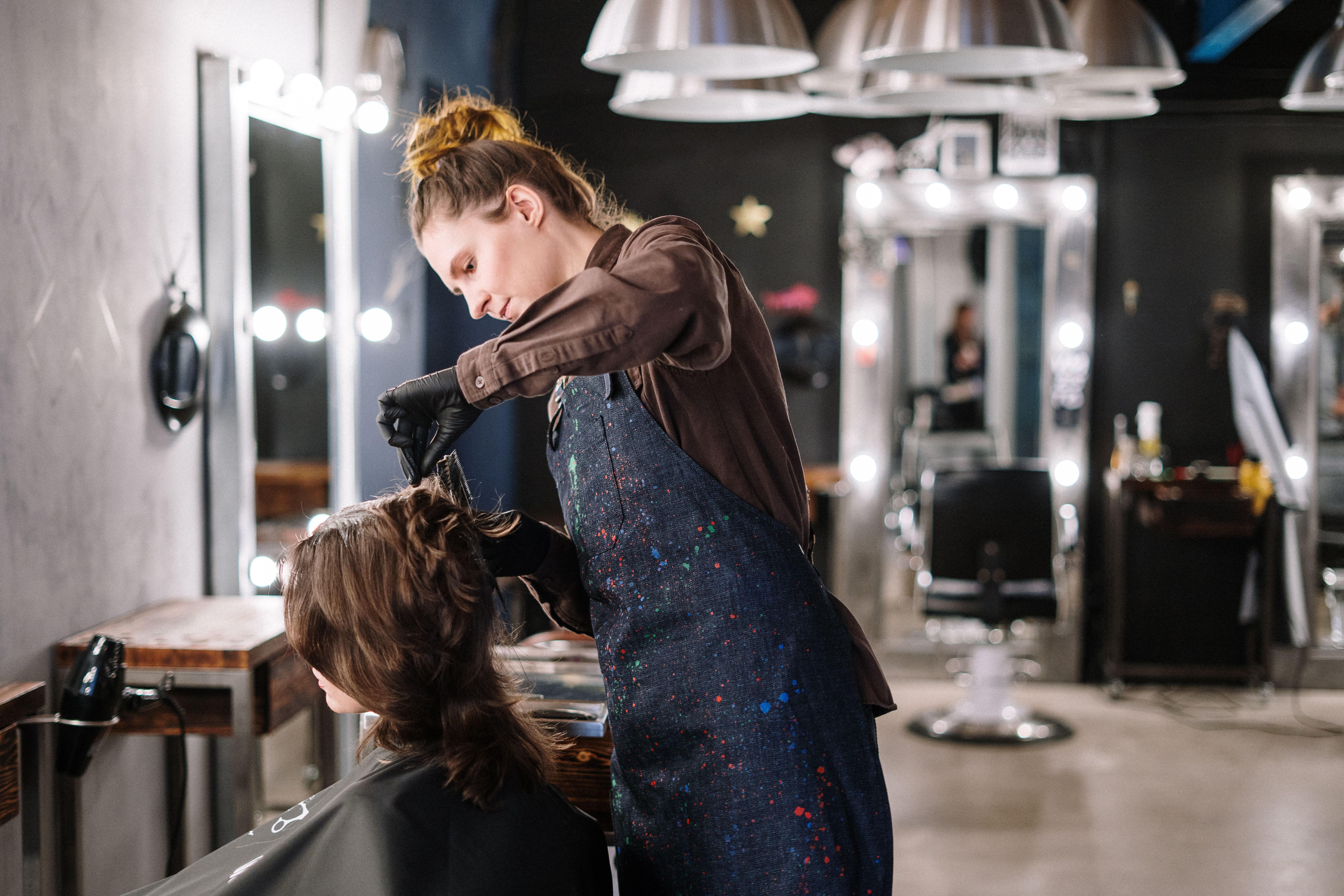 Self-employed hairdresser styling a client's hair in a modern salon