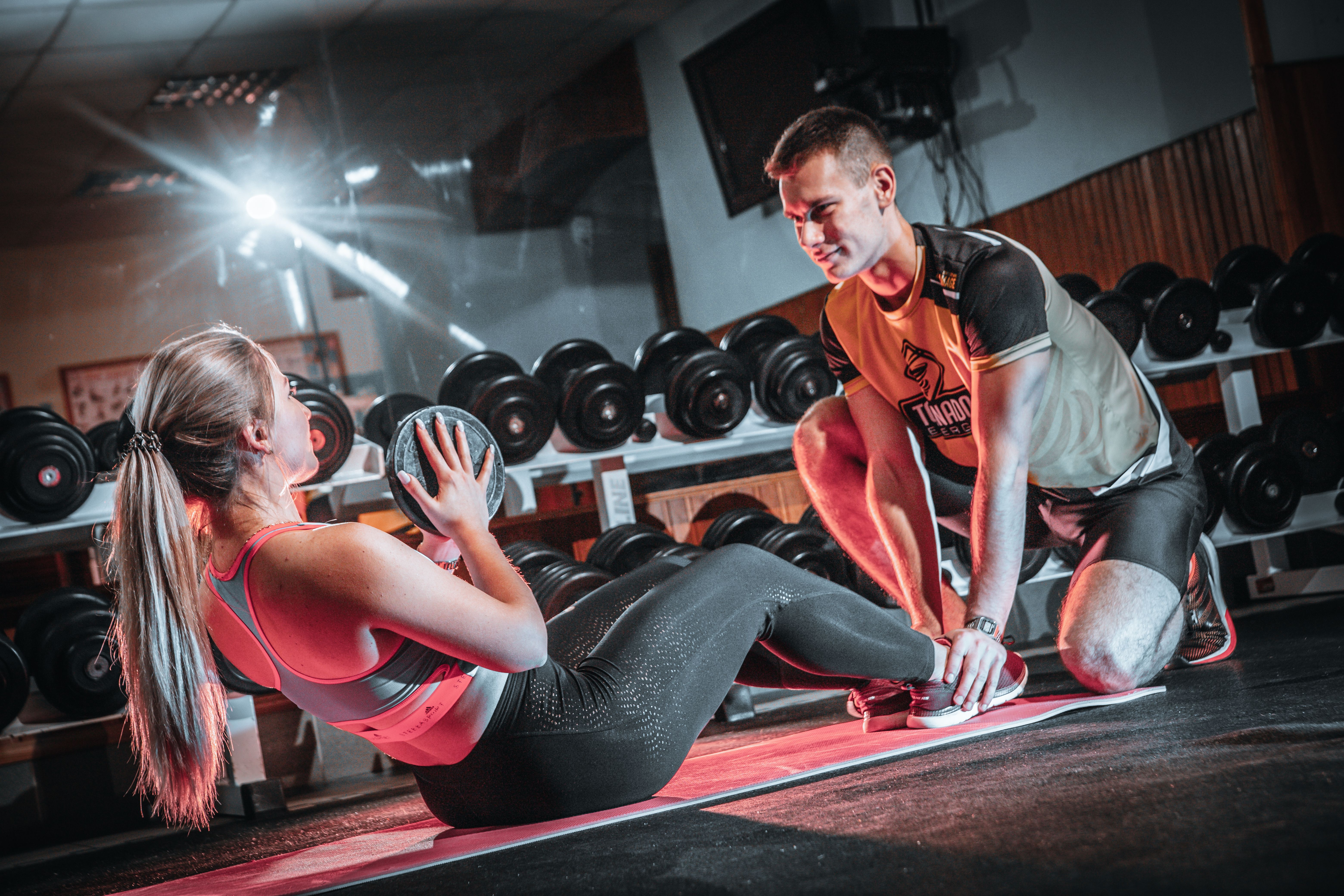 Personal trainer coaching a client during a gym workout session