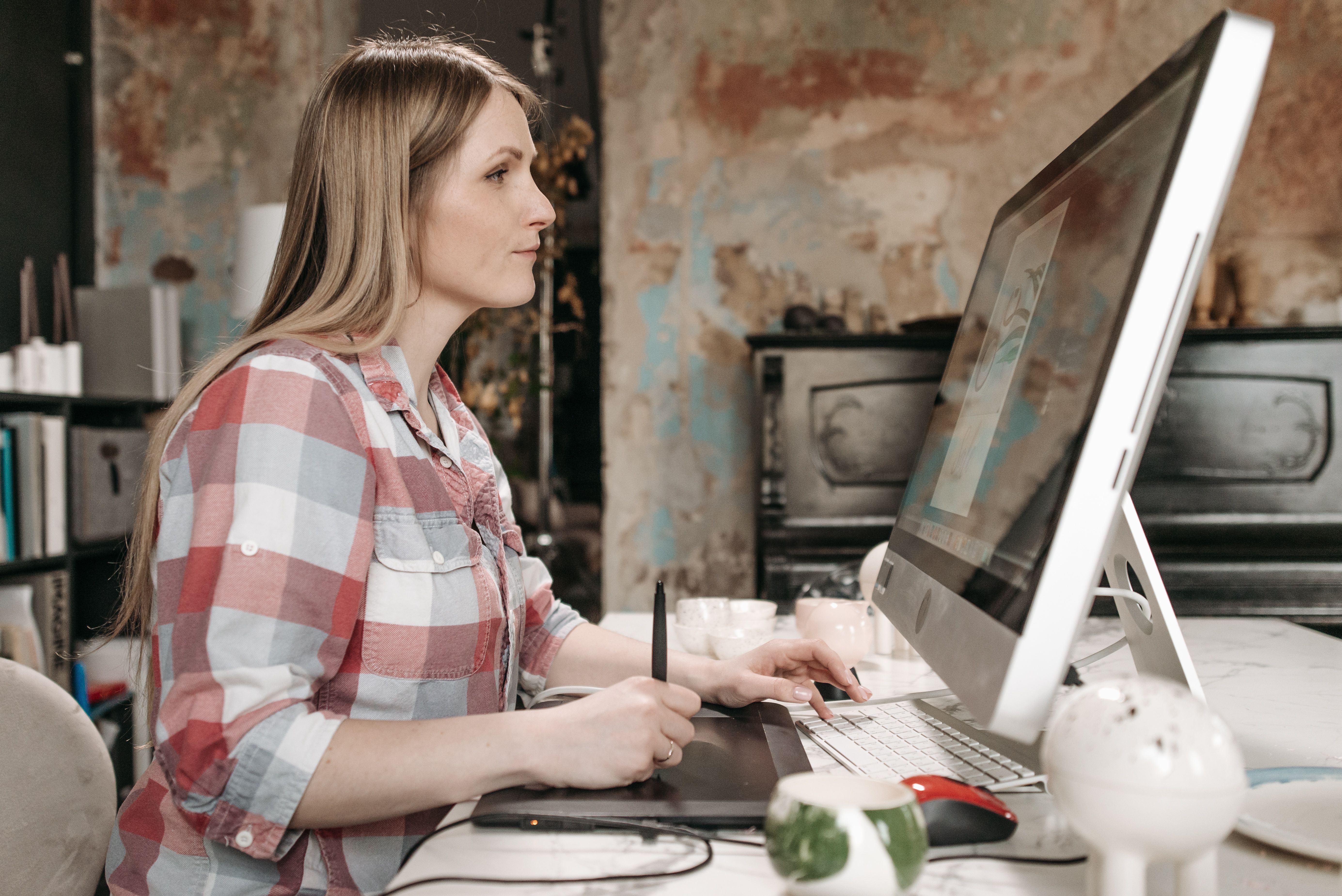 Self-employed creative professional working at her desk with a graphics tablet