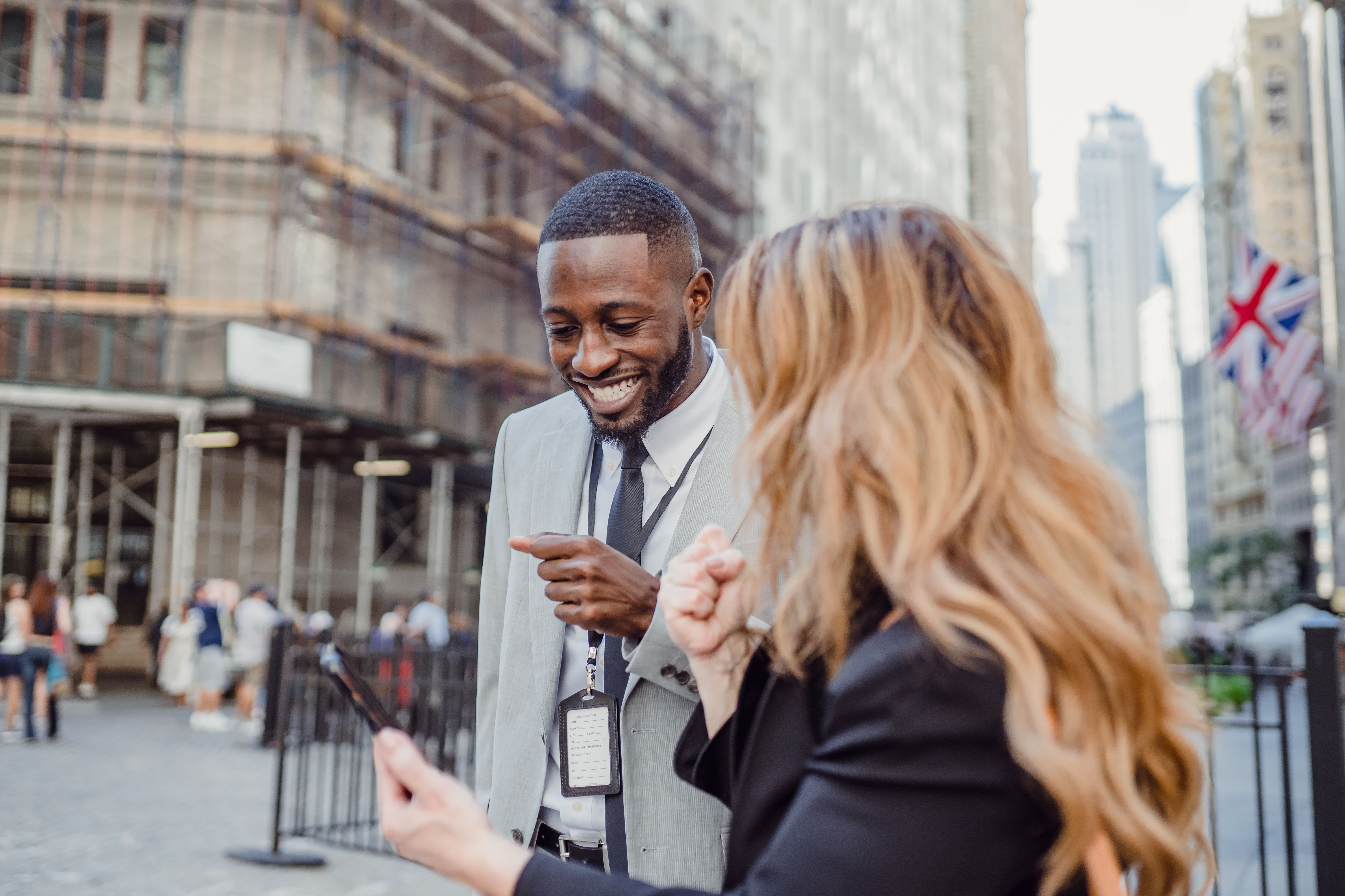 Two small business professionals speaking together outdoors in a city business district